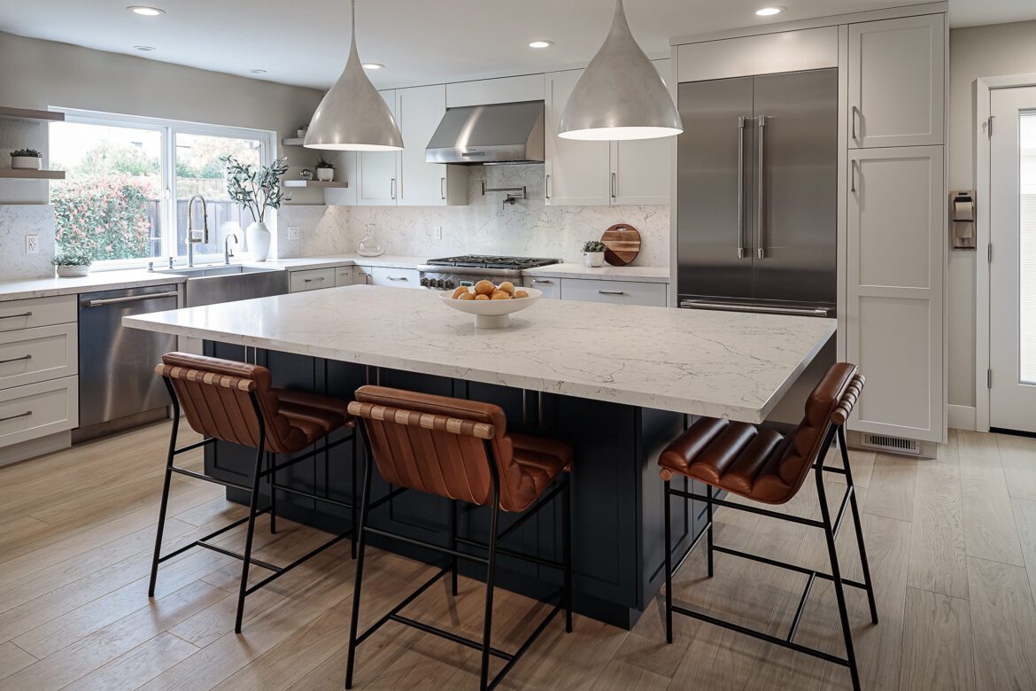 large blue kitchen island with white quartz countertop and white quartz backsplash