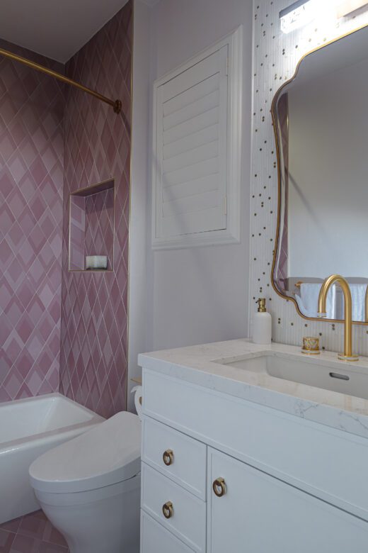 girls bathroom remodel with pink tile white vanity and gold fixtures